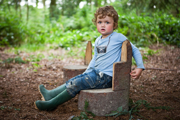 Child sitting on a wooden log