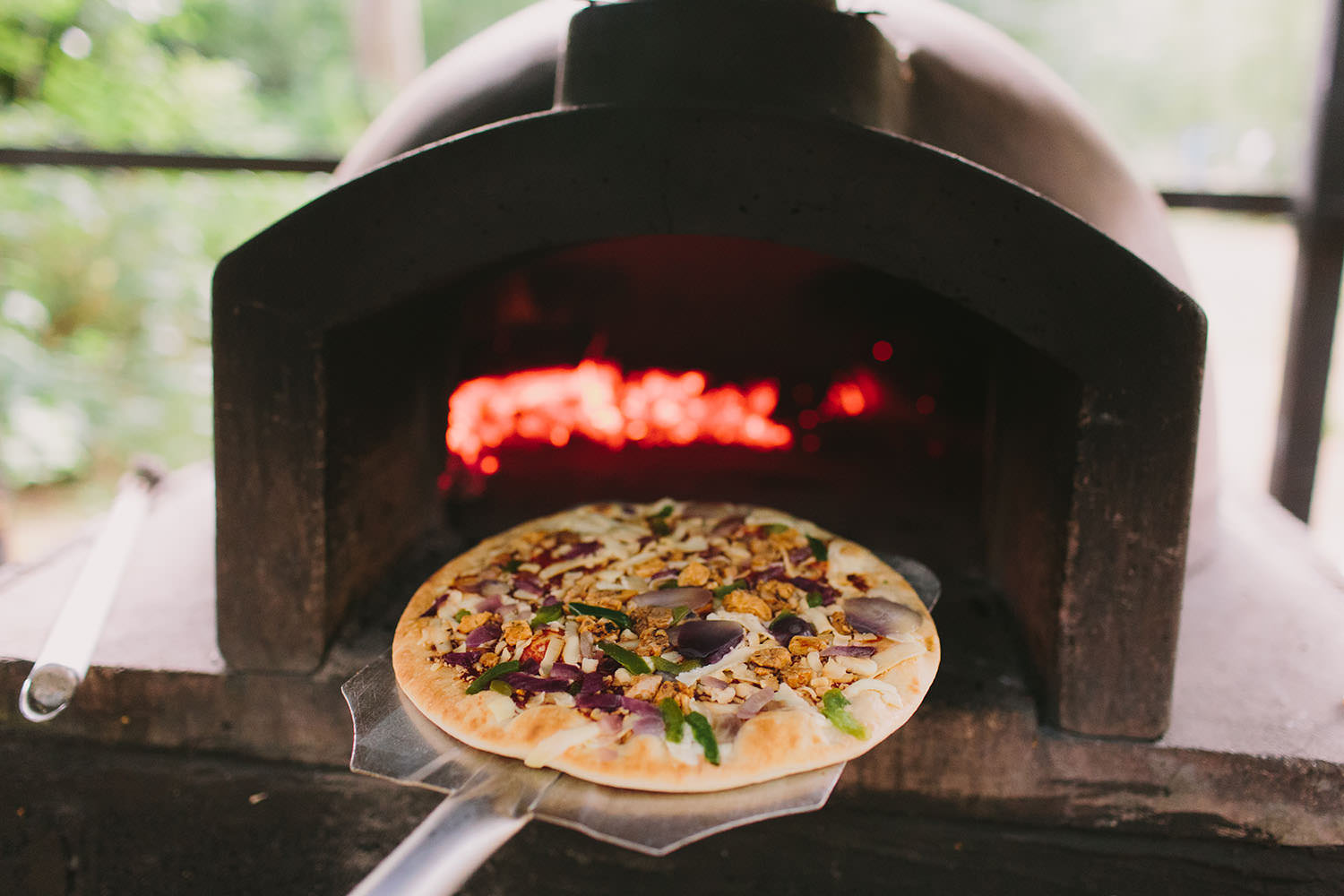 Pizza going in to a pizza oven