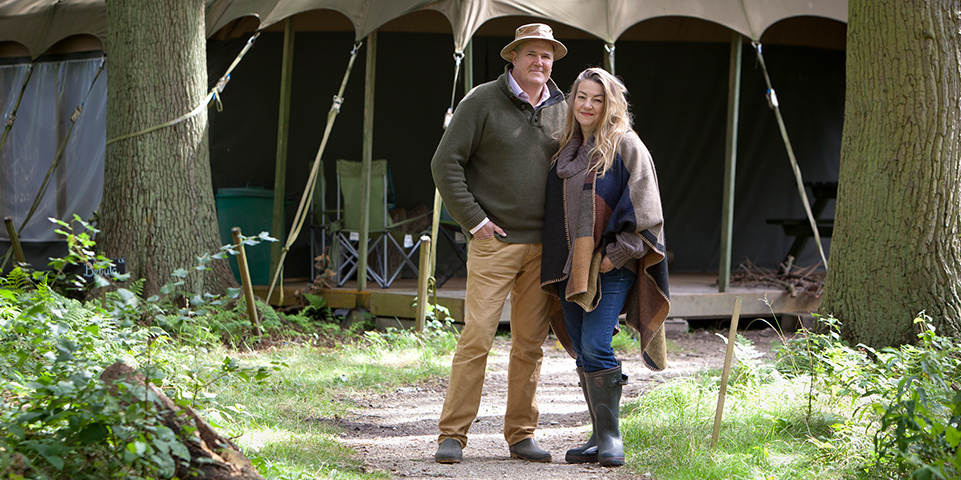 Carolyn and Christian standing outside of a tent